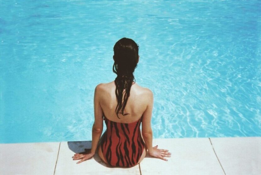 プールサイドに座る女性